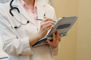 Physician making notes on handheld device