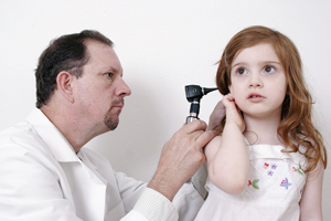 Medical provider examining little girl's painful ear