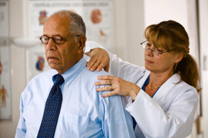 Medical provider checking man's painful shoulder