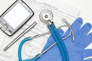 Stethoscope, blue gloves, pen, patient's chart, and other medical items