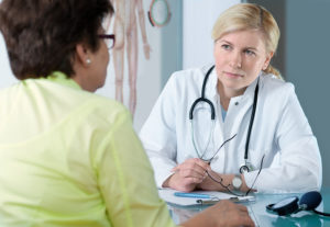Doctor talking with patient during physical exam
