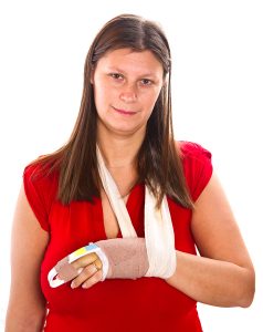 Woman with a broken finger and injured wrist in a sling