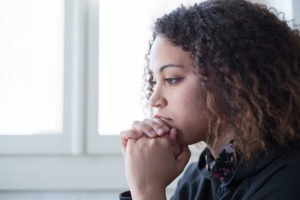 Pensive young woman thinking about getting an HIV test