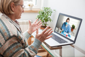 Woman interacting with medical provider via laptop during virtual visit