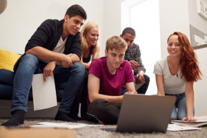 Group of college students studying together in lounge of shared dorm hall